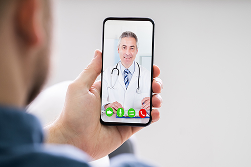 Person-Videochatting-With-Doctor-On-Mobile-Phone