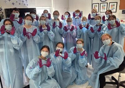 University High School juniors participate in hands-on training, practicing proper use of personal protective equipment (PPE) as part of their healthcare career exploration.