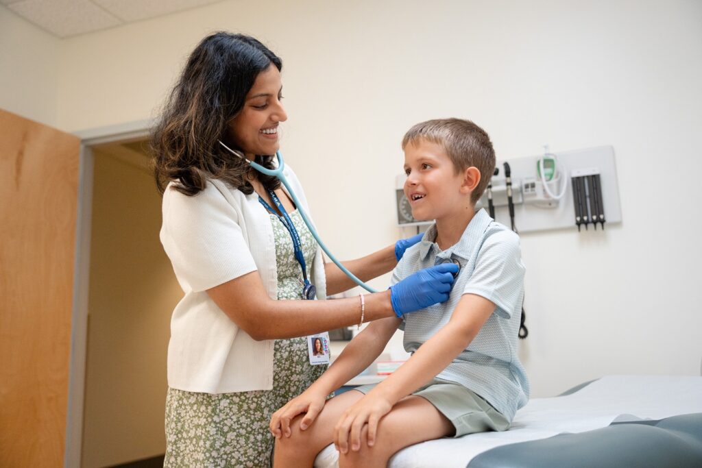 Doctor listening to child heart